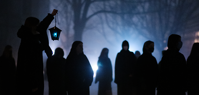students with lanterns at night