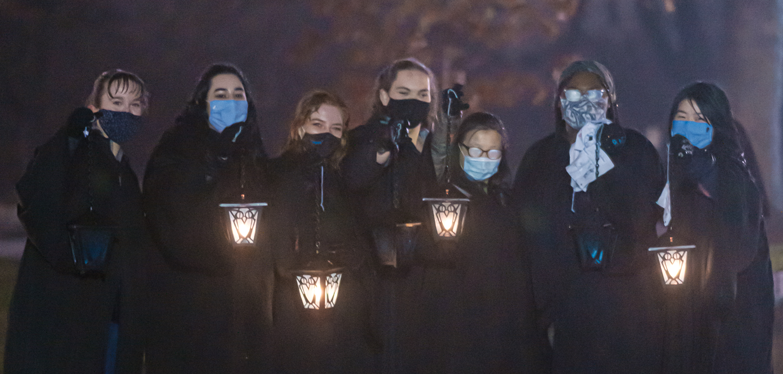 students with lanterns at night